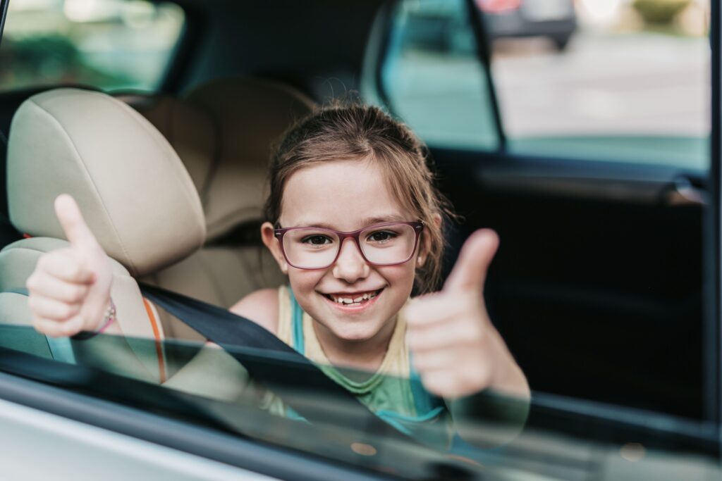 Cute girl sitting in a car on a safety child car seat.